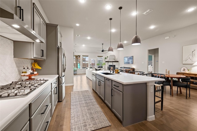 11721 Bull Creek Dr, Northlake, TX 76226 - kitchen featuring range hood, appliances with stainless steel finishes, gray cabinets, open floor plan, and dark wood-type flooring
