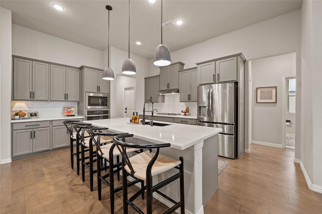 11721 Bull Creek Dr, Northlake, TX 76226 - kitchen featuring stainless steel appliances, gray cabinets, decorative backsplash, a breakfast bar, and recessed lighting