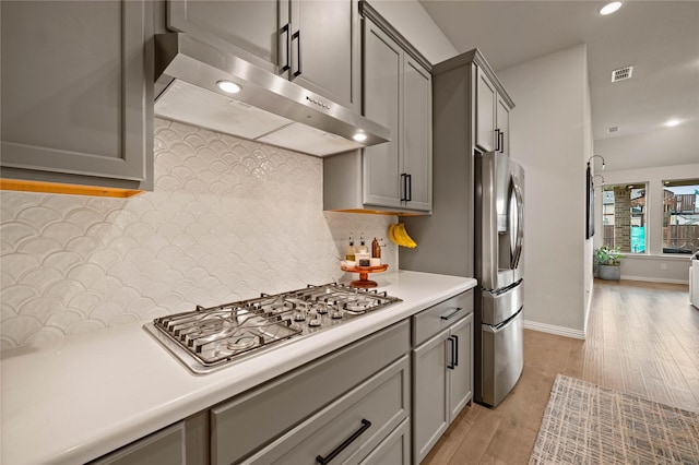 11721 Bull Creek Dr, Northlake, TX 76226 - kitchen featuring extractor fan, appliances with stainless steel finishes, gray cabinets, light countertops, and light wood-type flooring