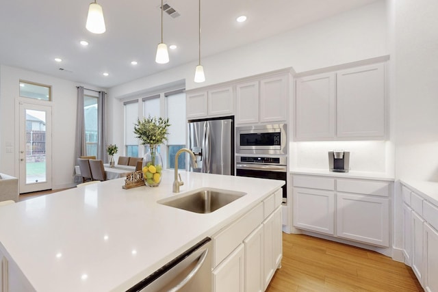 kitchen featuring light countertops, a sink, appliances with stainless steel finishes, and visible vents