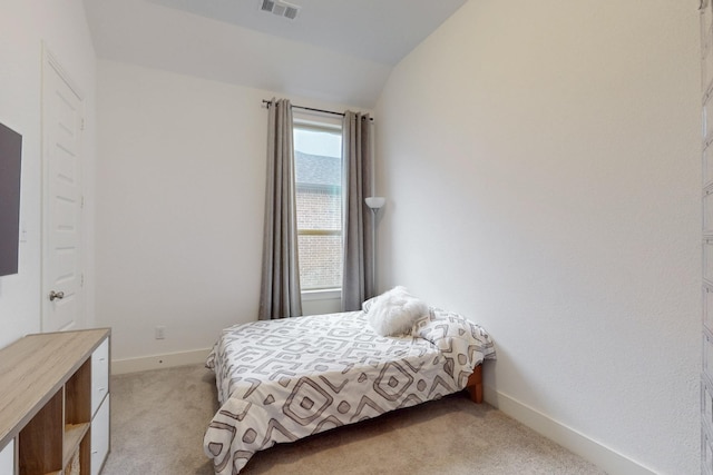 bedroom with baseboards, visible vents, light colored carpet, and vaulted ceiling