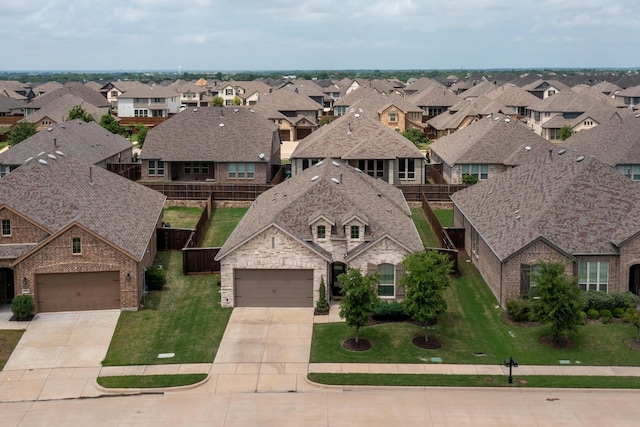 view of front of property featuring driveway, a front yard, a residential view, and stone siding