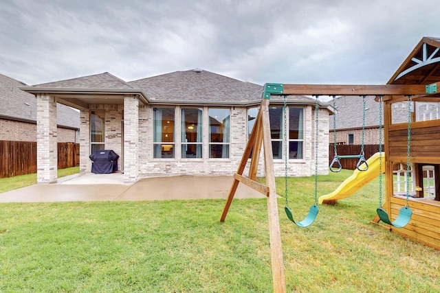 view of jungle gym with a patio, a fenced backyard, and a lawn