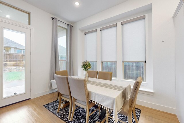 dining room with baseboards, recessed lighting, a wealth of natural light, and light wood-style flooring