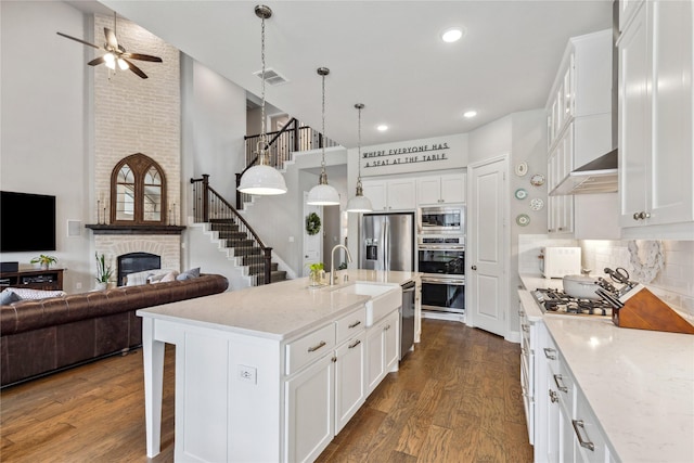 kitchen featuring a high ceiling, visible vents, a sink, appliances with stainless steel finishes, and ceiling fan