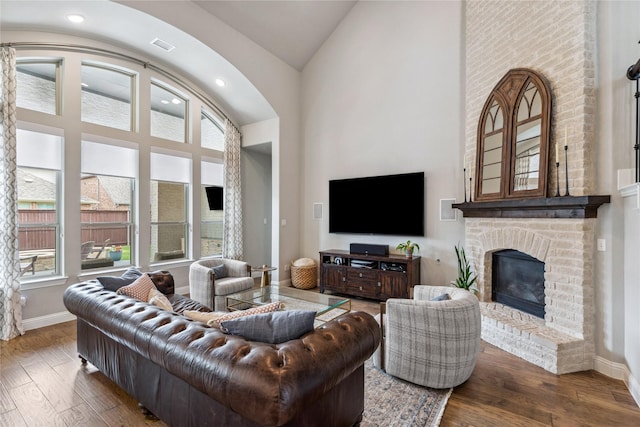 living area featuring high vaulted ceiling, a healthy amount of sunlight, and wood finished floors