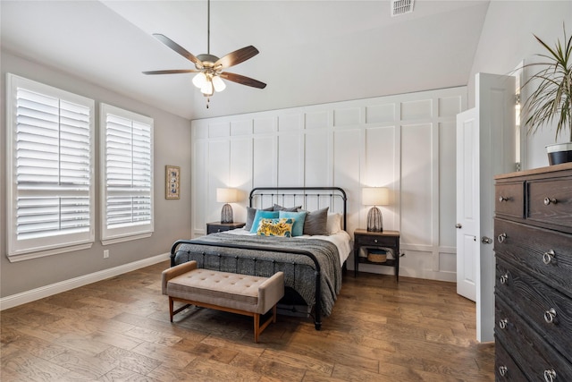 bedroom featuring wood finished floors, visible vents, lofted ceiling, and baseboards