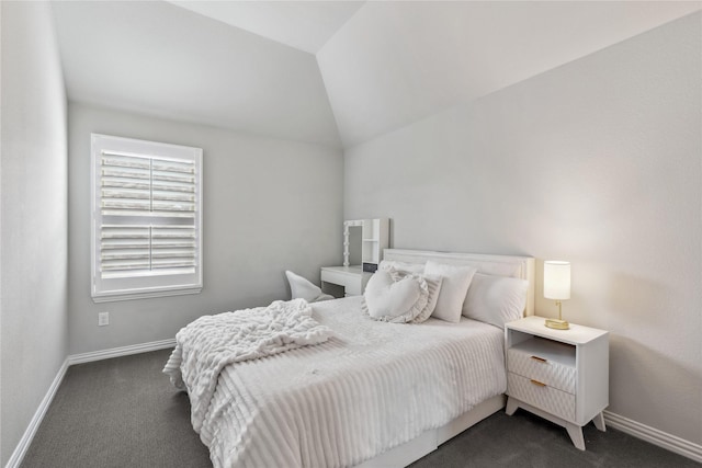 bedroom featuring lofted ceiling, baseboards, and dark carpet