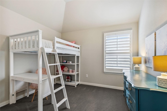 bedroom with dark colored carpet and baseboards