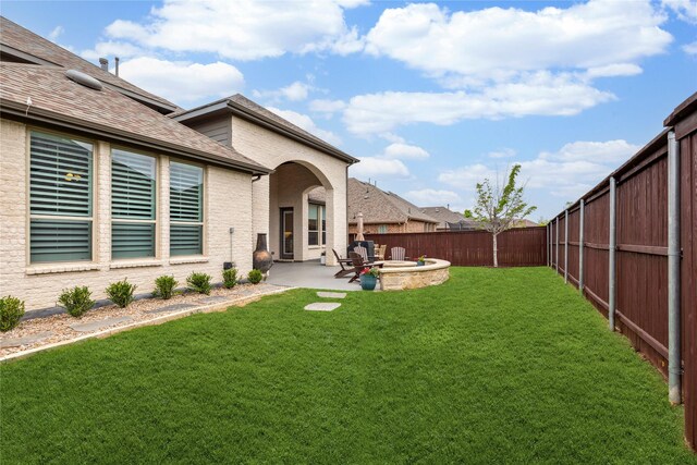 view of yard featuring a fire pit, a patio area, and a fenced backyard