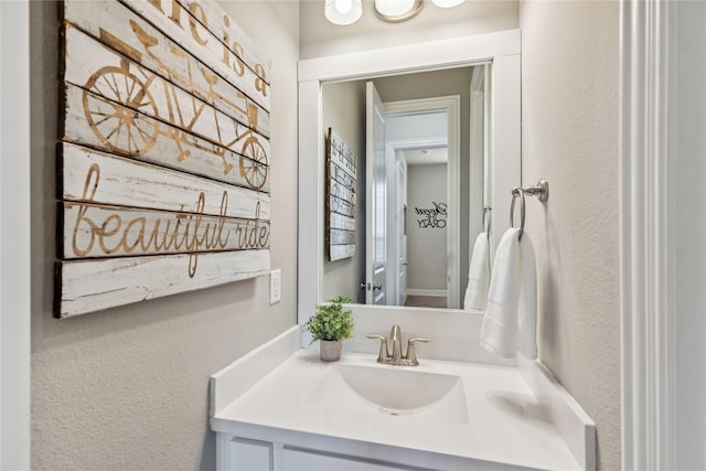 bathroom featuring a textured wall and vanity