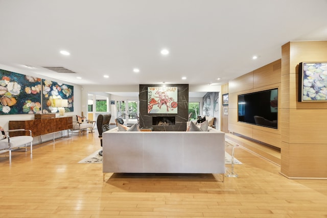 living area featuring a fireplace, light wood-style floors, visible vents, and recessed lighting