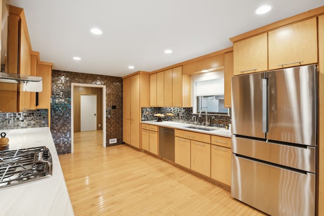 kitchen featuring light countertops, light brown cabinetry, appliances with stainless steel finishes, and a sink
