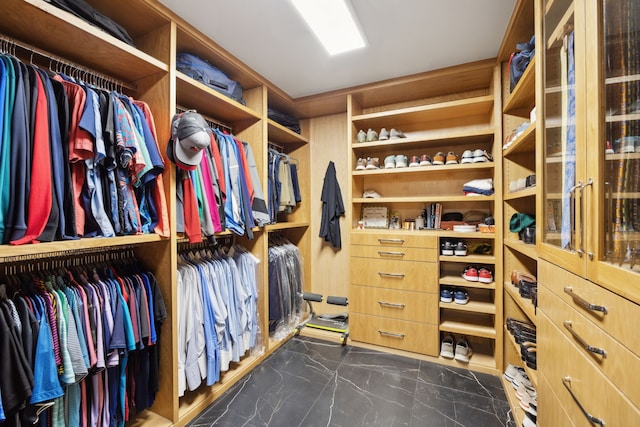 walk in closet with marble finish floor