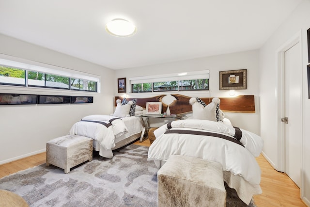 bedroom with baseboards and wood finished floors