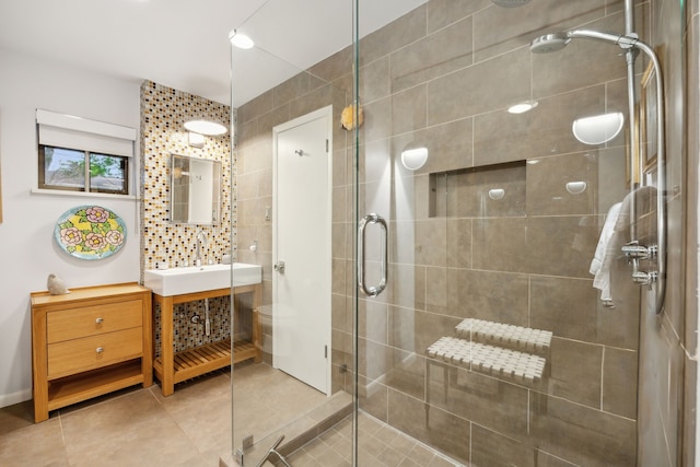 full bath featuring a shower stall, tile patterned flooring, vanity, and tile walls