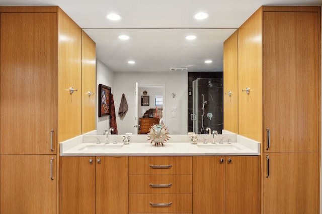 bathroom featuring recessed lighting, double vanity, a stall shower, and a sink