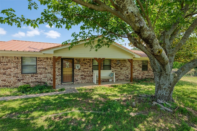 113 S Hill Top Ct, Springtown, TX 76082 - property entrance featuring a lawn, brick siding, and metal roof