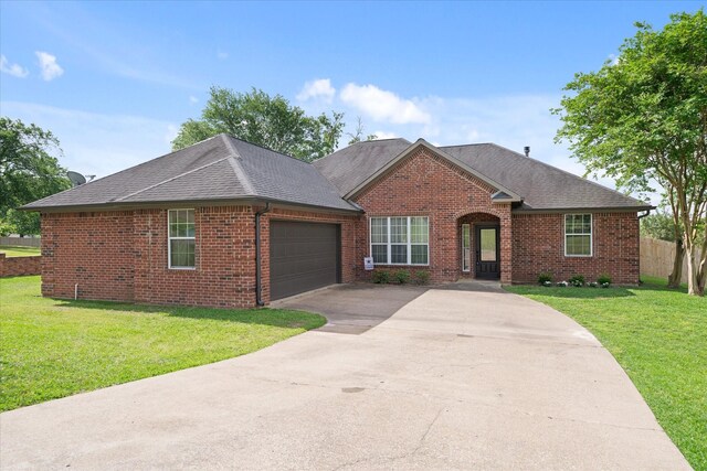 ranch-style house with concrete driveway, brick siding, roof with shingles, and a garage