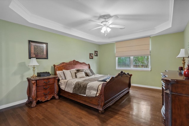 bedroom with ornamental molding, baseboards, a raised ceiling, and dark wood-style flooring