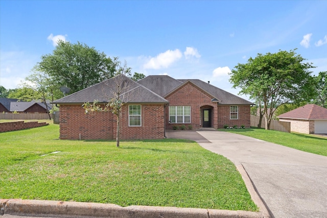 ranch-style house with fence, brick siding, a front yard, and concrete driveway
