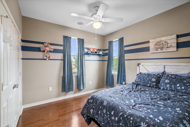 bedroom with wood finished floors, baseboards, and ceiling fan