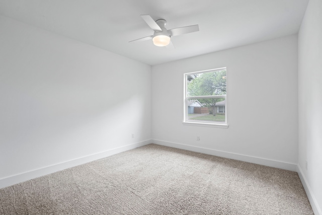 carpeted spare room featuring baseboards and ceiling fan