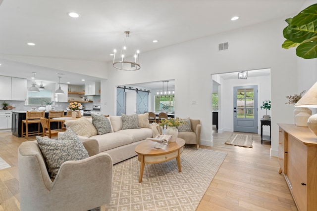 living room with light wood finished floors, visible vents, recessed lighting, and a notable chandelier