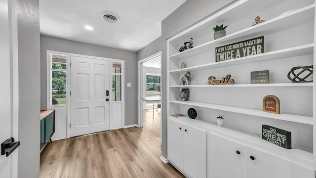 entrance foyer with baseboards, visible vents, a healthy amount of sunlight, and light wood-style floors