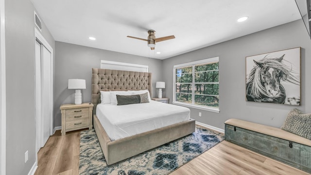 bedroom with baseboards, recessed lighting, wood finished floors, and visible vents