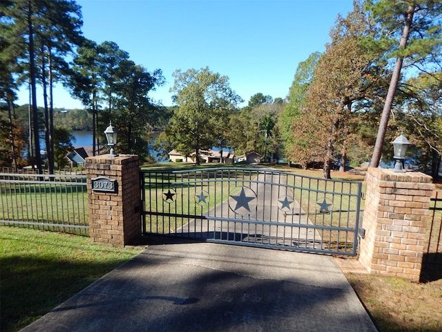 view of gate featuring fence and a lawn