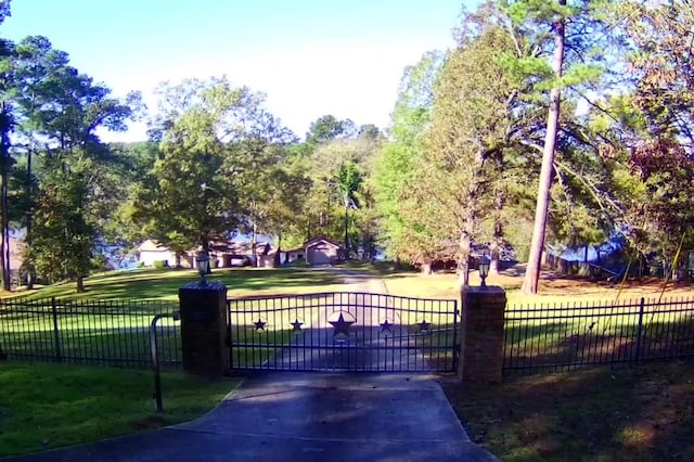 view of gate with a lawn and fence