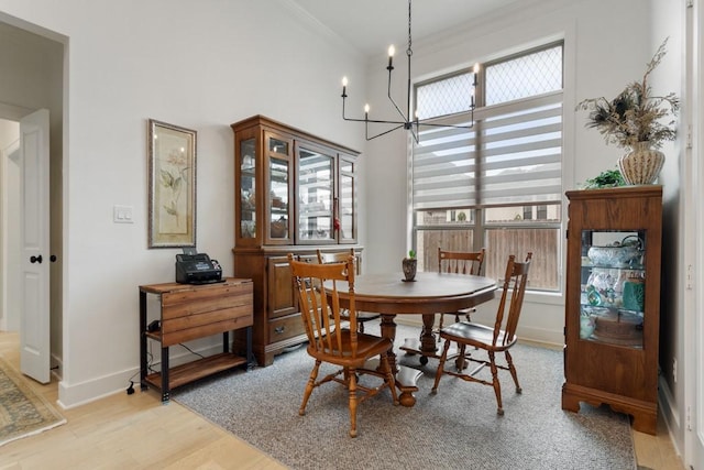 dining room with baseboards, light wood-style floors, a notable chandelier, and ornamental molding