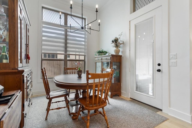 dining area with baseboards, an inviting chandelier, light wood-style floors, and plenty of natural light
