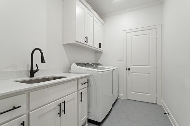 laundry area with a sink, washer and clothes dryer, ornamental molding, cabinet space, and light tile patterned floors