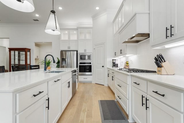 kitchen featuring stainless steel appliances, visible vents, ornamental molding, a sink, and tasteful backsplash