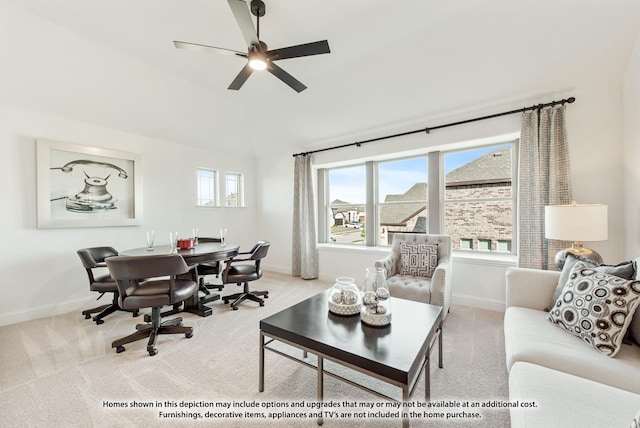 living area featuring lofted ceiling, carpet floors, a ceiling fan, and baseboards