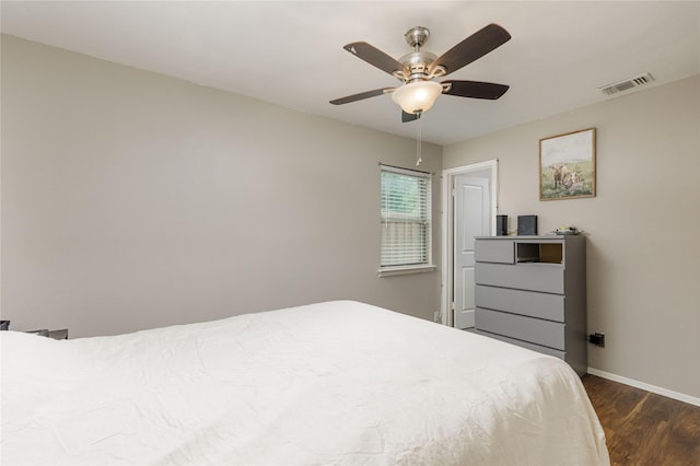bedroom with baseboards, a ceiling fan, visible vents, and dark wood finished floors