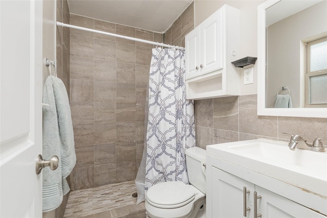 bathroom featuring a tile shower, toilet, vanity, and tile walls