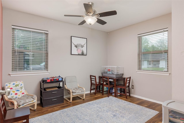 interior space with baseboards, a ceiling fan, and wood finished floors