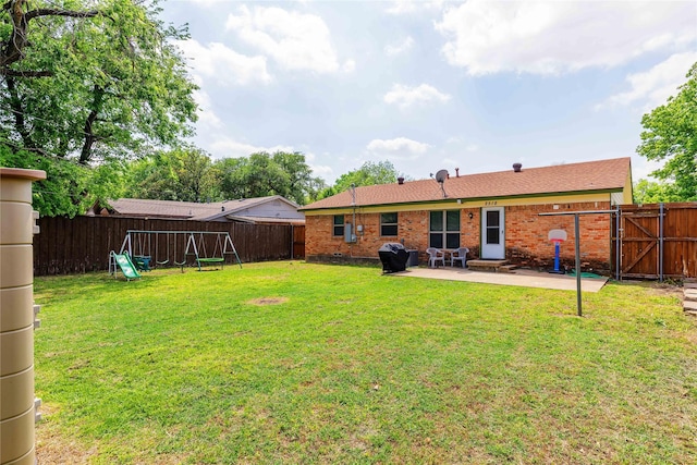 view of yard with a patio area, a fenced backyard, a gate, and a playground
