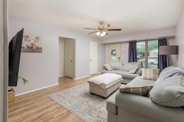 living room with light wood finished floors, baseboards, and ceiling fan