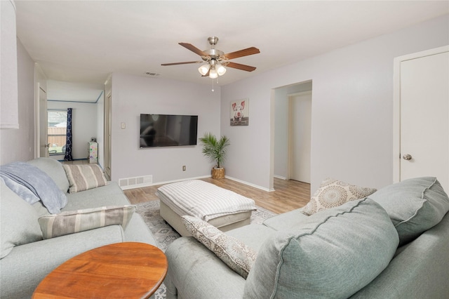 living room with visible vents, a ceiling fan, and wood finished floors