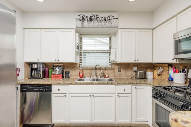kitchen featuring white cabinets, a sink, tasteful backsplash, recessed lighting, and appliances with stainless steel finishes