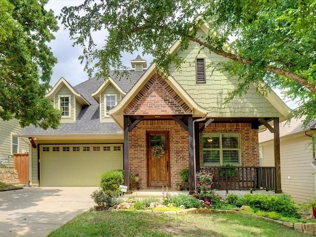 craftsman-style home with concrete driveway, brick siding, a shingled roof, and a garage