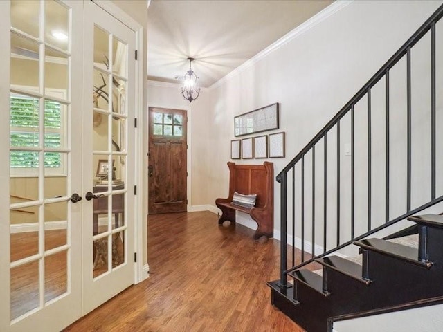 foyer with french doors, wood finished floors, stairs, and ornamental molding