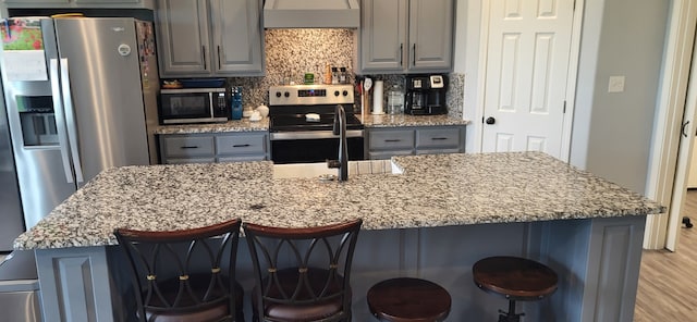 35 County Road 2342, Sulphur Springs, TX 75482 - kitchen with wall chimney exhaust hood, decorative backsplash, appliances with stainless steel finishes, and gray cabinets