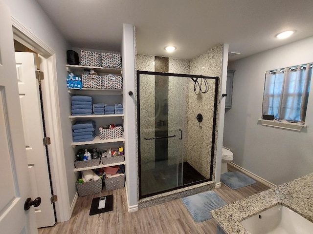 35 County Road 2342, Sulphur Springs, TX 75482 - bathroom featuring wood finished floors, toilet, a sink, baseboards, and a stall shower