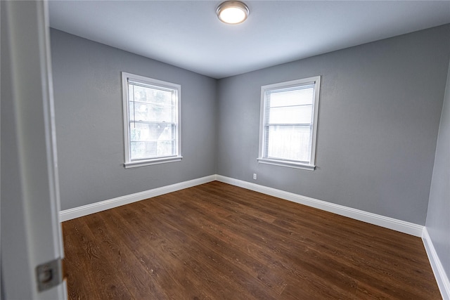 3143 Grayson Dr, Dallas, TX 75224 - empty room with healthy amount of natural light, dark wood-style flooring, and baseboards
