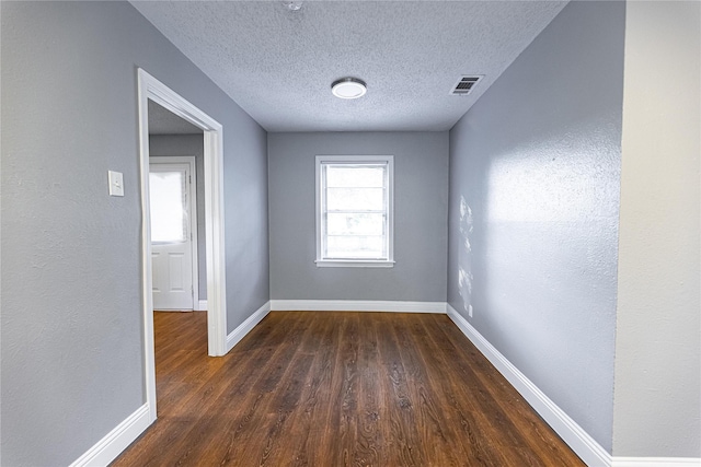3143 Grayson Dr, Dallas, TX 75224 - spare room featuring dark wood finished floors, baseboards, a textured ceiling, and a textured wall